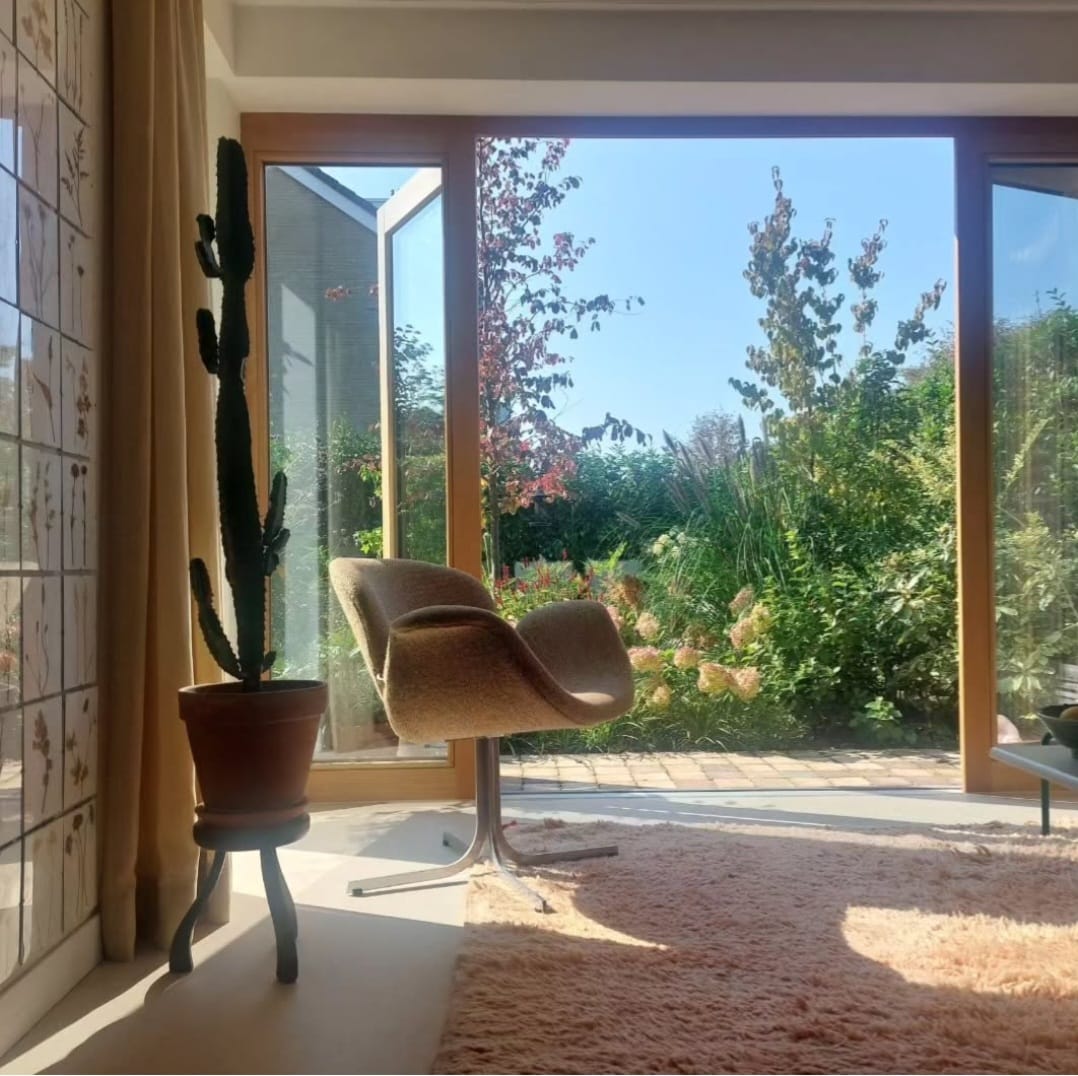 Woonkamer met accent stoel en tuinuitzicht